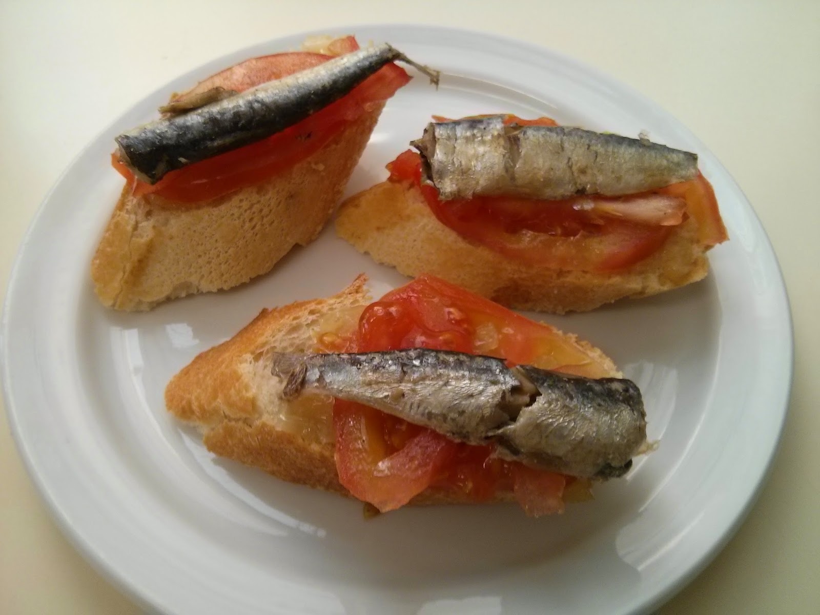 Tosta de cebolla caramelizada con tomate y sardinillas